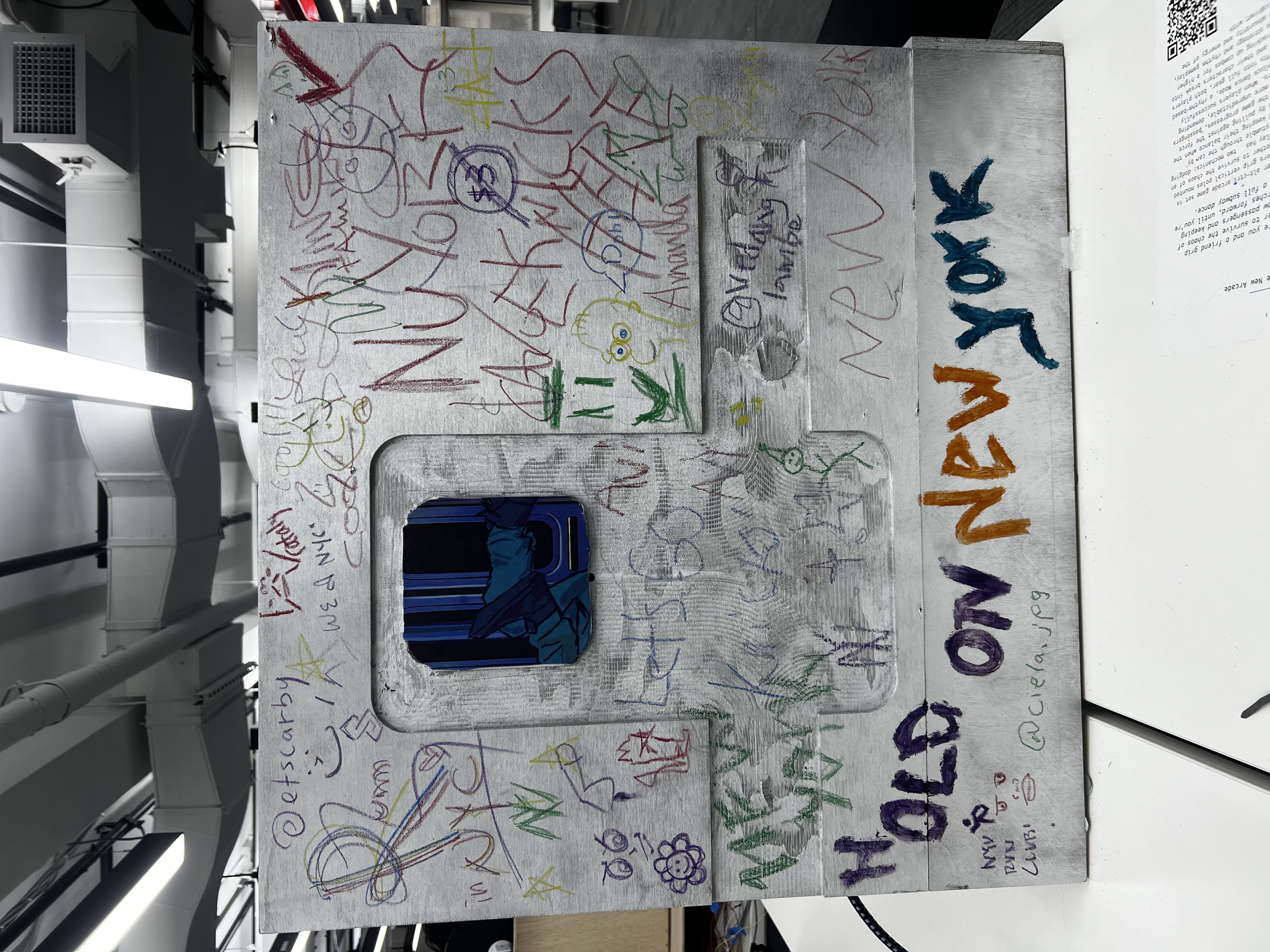 Side of the arcade cabinet covered in crayon drawings and tags from players